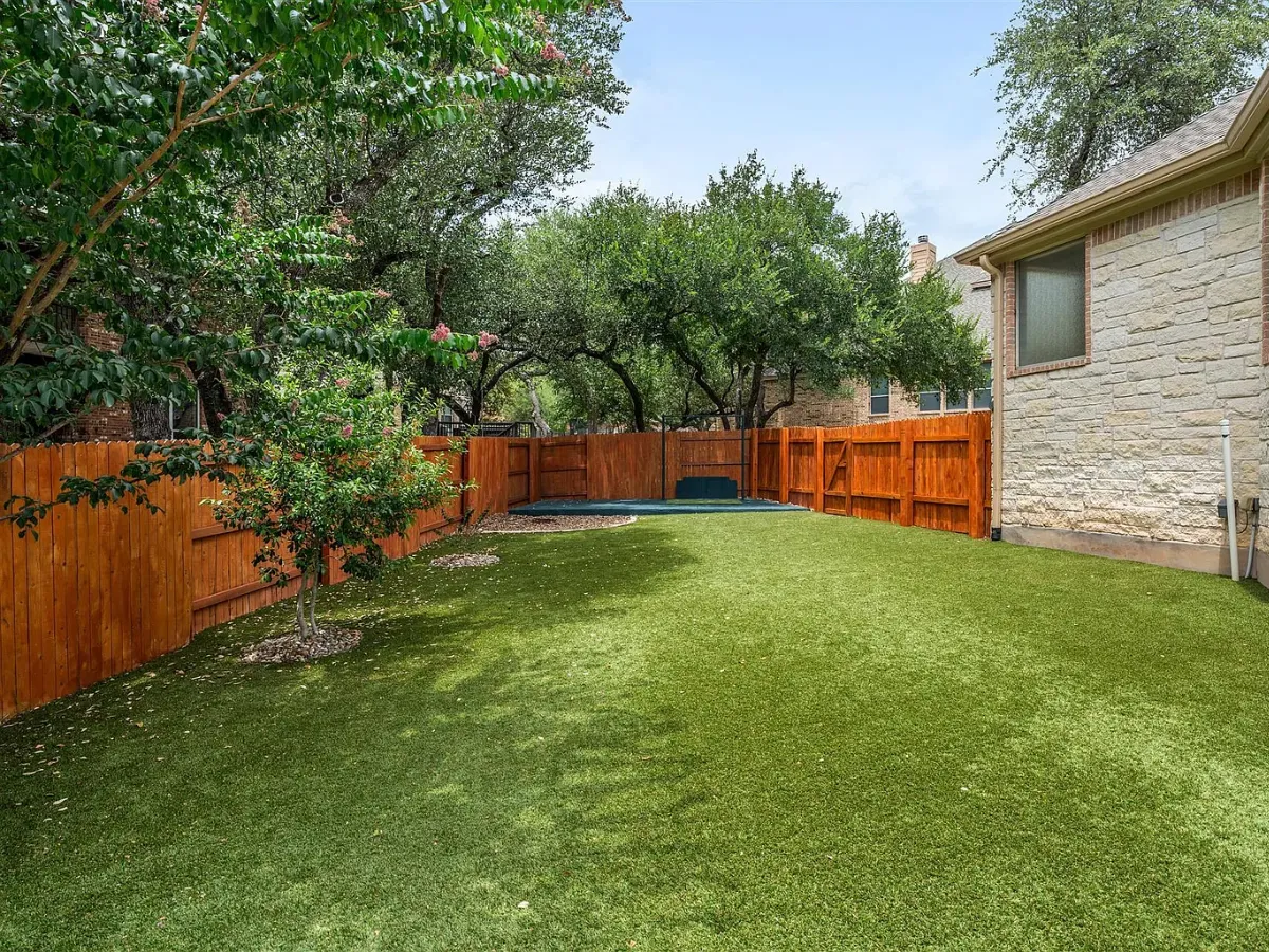 Artificial turf lawn in a fenced backyard with a wood privacy fence in Tega Cay, SC